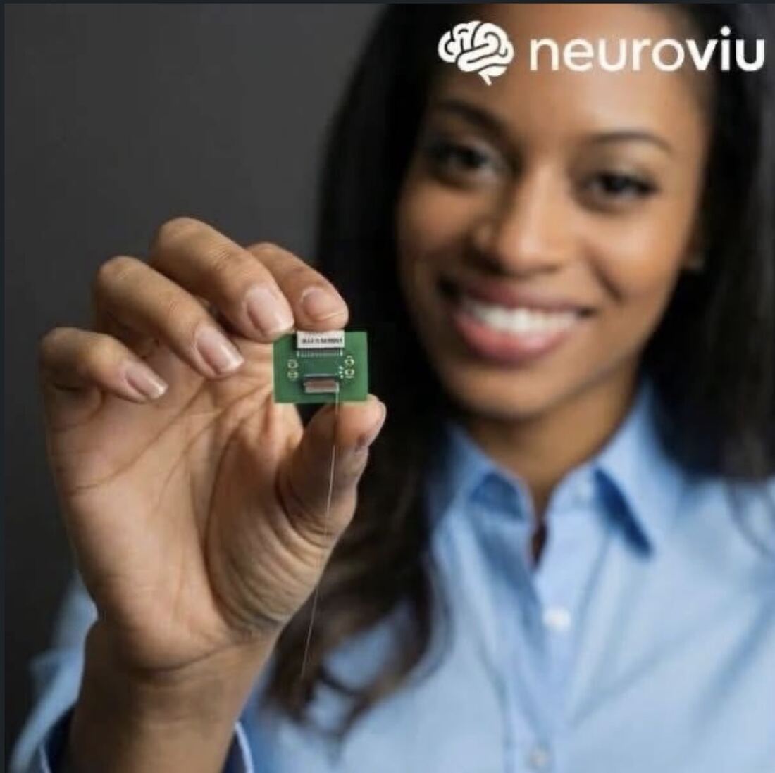 A person holding the compact NeuroViu wearable EEG module between two fingers.
